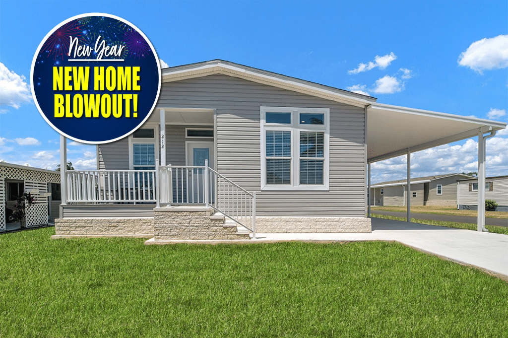 Single-story manufactured home with covered carport and front porch, set on a grassy lot. A circular "New Year New Home Blowout!" graphic is in the top left corner.